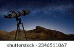 telescope on a tripod pointing at starry night sky