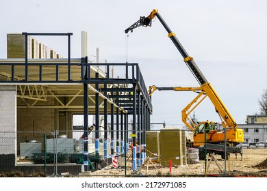 Telescopic boom crane and self propelled lift at metal construction frames assemblage - Shutterstock ID 2172971085