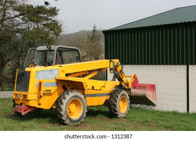 Telescopic Loader Tipping Gravel Next To A Building,