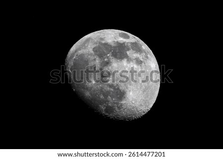 A telescopic view of the rough surface of the bright full Moon in a black night sky, in grayscale