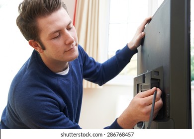 Television Engineer Installing New TV At Home