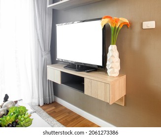 The Television Is Placed On A Wall Mounted TV Cabinet In Living Room, Decorated With Flower Vases.