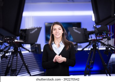 Television Presenter Recording In News Studio.Female Journalist Anchor Presenting Business Report,recording In Television Studio.News Camera,light Equipment Behind The Scenes. TV Program Editor.