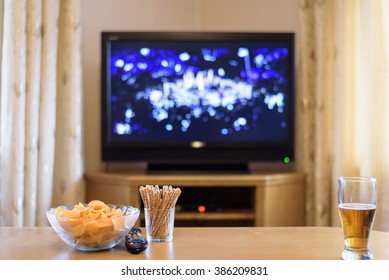 Television, TV Watching (boxing Match) With Snacks And Alcohol Lying On Table - Stock Photo