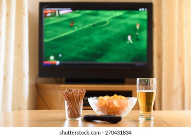 Television, TV Watching (football, Soccer Match) With Snacks Lying On Table - Stock Photo