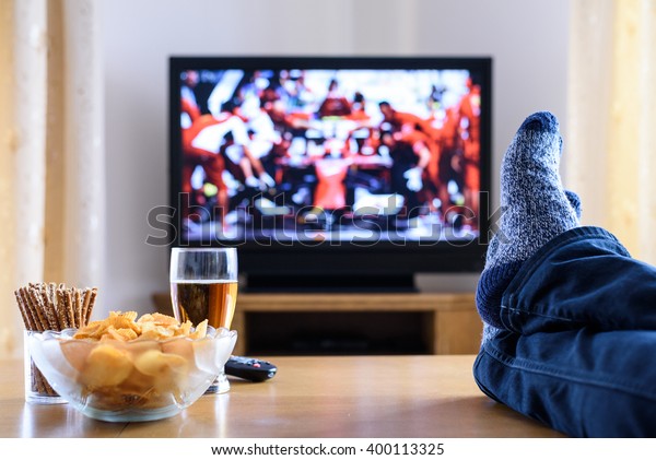 Television, TV watching (formula one race) in\
living room with feet on table - stock\
photo