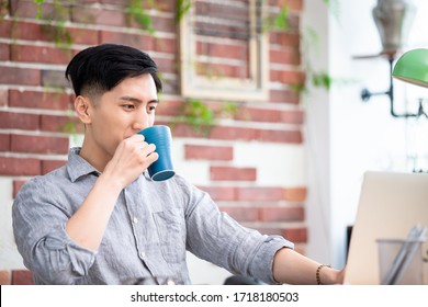 Telework Concept - Asian Man Use Computer To Join A Video Meeting And Drinking Coffee At Home