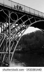 TELFORD, UK - February 18, 2013. A Group Of Tourists Cross The Iron Bridge, The First Cast Iron Arch Bridge Built Over Ironbridge Gorge At The Start Of The Industrial Revolution. Monochrome Image.