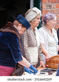 Telford,England-  June 22nd 2013: Ladies dressed in vintage clothes re-enacting wartime rationing as part of a 1940s event. Ladies at Blists hill industrial museum some motion blur