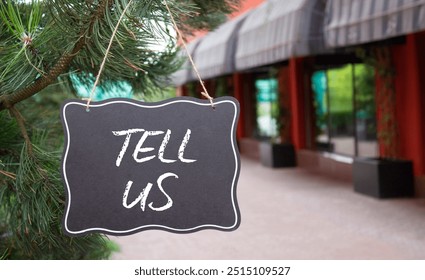 Tell us symbol. Concept words Tell us on black chalk blackboard. Beautiful background with shop and tree. Business and Tell us concept. Copy space. - Powered by Shutterstock