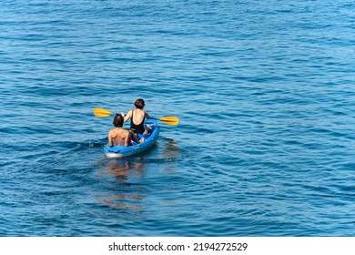 TELLARO, ITALY - July 19, 2022: A Mature Couple Aboard A Blue Kayak, Paddling In The Blue Mediterranean Sea, On A Sunny Summer Day. Gulf Of La Spezia, Liguria, Italy, Southern Europe.