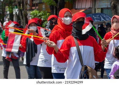 Temanggung, Indonesia - August 17, 2022 : A Person In A Red And White Costume Holding A Small Flag In His Hand During The Annual Fastival Of Indonesian Independence. Good For Photo Documentation, Blog