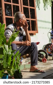 Temanggung, Indonesia - June 29, 2022 : Old Man Sitting On The Porch Smoking