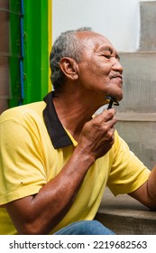 Temanggung, Indonesia - October 20, 2022 : An Old Man Shaving His Beard