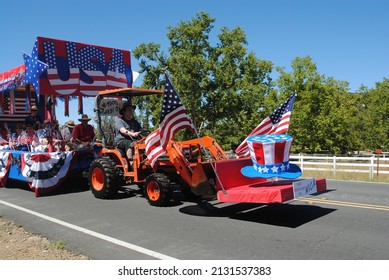 Temecula, California, USA, July 4, 2016, A Decorated Kubota Tractor Pulls a Parade Float with an Uncle Sam Hat and American Flags in a Fourth of July Parade