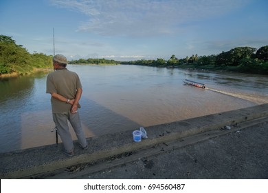 TEMERLOH,PAHANG-MARCH 23 2017:Unrecognized Old Malay Man At The Edge Of Sungai Pahang River During Late Evening For Fishing