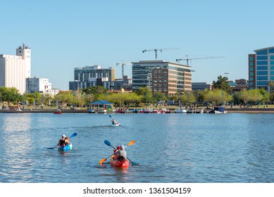 Tempe, USA - March 30, 2019: A family of kayakers paddle across Tempe Town Lake in Arizona.