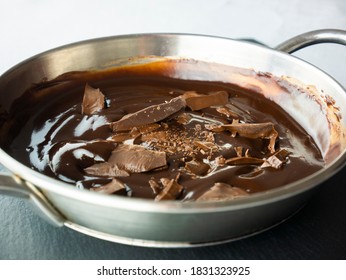 Temper the chocolate in a saucepan. Pieces of chocolate. Preparing cocoa mousse. Cooking sweets. Top view. Still life food. - Shutterstock ID 1831323925