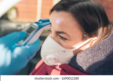 Temperature Check Point - The Woman Behind The Wheel Of The Car In An Anti-virus Mask Is Subjected To Temperature Measurement. Coronavirus Concept - Restrictions, Quarantine, Isolation