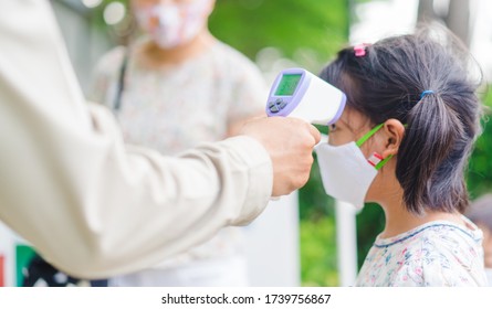 temperature check in school kid girl at school.Open school first health check up measurement.Asian girl measuring body temperature and wearing a face mask before go back to school.Healthcare medical. - Powered by Shutterstock