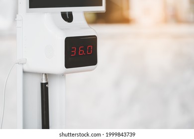 Temperature Digital Scanner Machine Showing Temperature  On Blurred Reception Counter Background For Screening Customer To Protection Transmission Of Covid19 