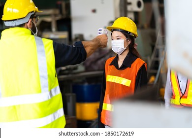 Temperature Measurement With Employee Temperature Meter Before Entering Work At Factory. Professional Engineering Team.