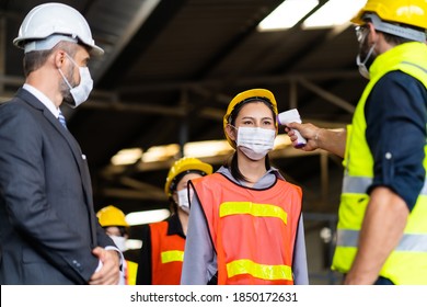 Temperature Measurement With Employee Temperature Meter Before Entering Work At Factory. Professional Engineering Team.