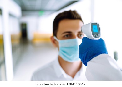 Сhecking the temperature of office workers during the coronavirus pandemic. Covid-19. - Powered by Shutterstock