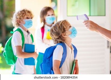 Temperature screening and medical check at school. Child in face mask in class in covid-19 outbreak. Teacher with thermometer at preschool entrance. Social distancing. Coronavirus prevention. - Powered by Shutterstock