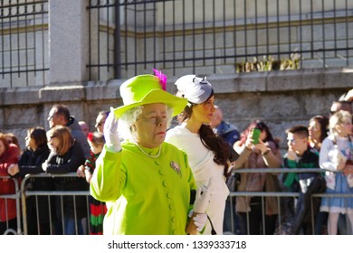 Tempio Pausania, Sardinia / Italy - 03 03 2019 : Man Disguised As Queen Elizabeth In A Lime Yellow Dress Arm In Arm With A Girl Dressed As Kate Middleton In A White Dress At The Carnival Parade