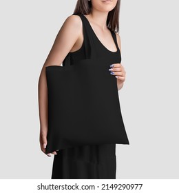 A Template Of A Black Totebag With A Handle, On The Shoulder Of A Girl In A Summer Sundress, A Reusable Ecobag For Retail, Shopping.Ecological Handbag Mockup For Design,pattern, Isolated On Background