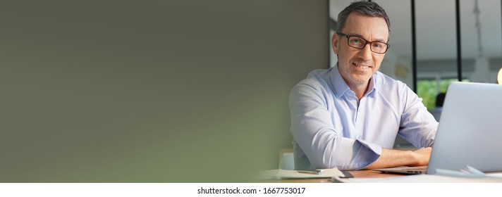 Template business manager working in office on laptop