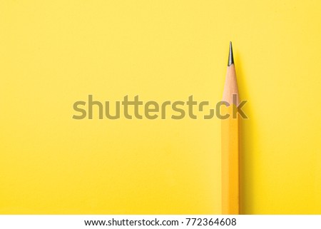 Template with copy space by top view closeup macro photo of wooden yellow pencil put on yellow paper that look minimal and clean. Side flash light made difference between them by highlight and shadow.