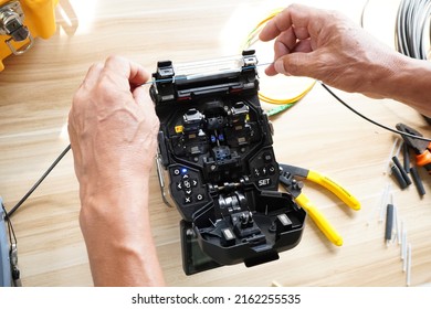 template Technician Fiberoptic Fusion Splicing. Worker connecting for Cable Internet signal and Wire connection with Fiber Optic Fusion Splicing machine,fiber optic cable splice machine in work