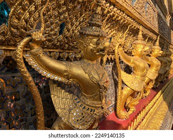 Temple of the Emerald Buddha.The central base of the ordination hall is decorated with a golden row of Garudas. each grasping within its claws two Naga serpents, surround all of the ordination hall. - Shutterstock ID 2249140135