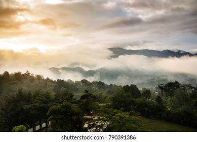 A Temple and pagoda on top of Beautiful mountains landscape with sunlight, clouds and fogs on morning of Northern, Thailand. Wide angle.