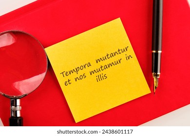 Tempora mutantur et nos mutamur in illis Translated from Latin, it means Times are changing, and we are changing with them. on a yellow sticker on a red notebook