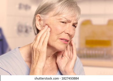 Temporal arteritis: senior woman suffering from painful jaw joints, filter effect.