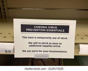 A Temporarily Out Of Stock Covid-19 Prevention Essentials Sign On An Empty Shelf At The Supermarket.