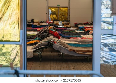 Temporary beds in a camp for refugees from Ukraine in Krakow, Poland. Temporary shelter for Ukrainian women and children fleeing the war in Ukraine - Shutterstock ID 2139170565