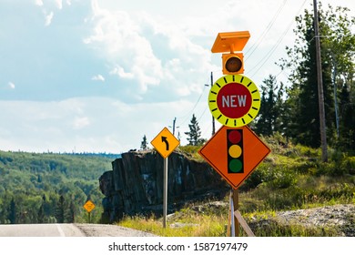 Temporary Condition Road Warning Signs On The Roadside Before Road Work Zone, New Signal Traffic Lights Ahead. With Lamp, And Left Curve Ahead Sign