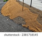 temporary covering of the lawn sowing with textiles to ensure a large slope against erosion. using brown jute fabric stabilizing coconut net for steep slopes. in heavy rain the soil does not leach out