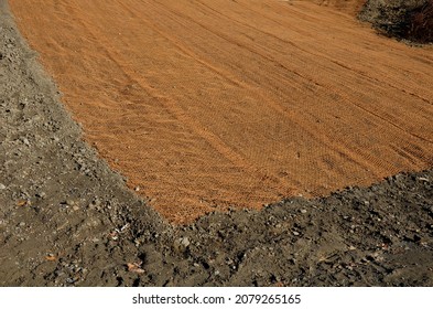 Temporary Covering Of The Lawn Sowing With Textiles To Ensure A Large Slope Against Erosion. Using Brown Jute Fabric Stabilizing Coconut Net For Steep Slopes. In Heavy Rain The Soil Does Not Leach Out