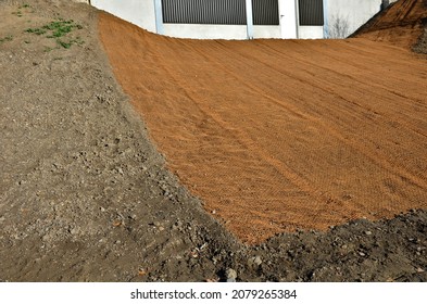 Temporary Covering Of The Lawn Sowing With Textiles To Ensure A Large Slope Against Erosion. Using Brown Jute Fabric Stabilizing Coconut Net For Steep Slopes. In Heavy Rain The Soil Does Not Leach Out