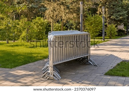 Temporary fencing. Security. Mass event. A large crowd of people. Portable sectional fence. Steel mobile fence on the street. Police fence.