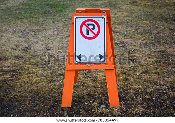 A temporary no parking barrier with right and\
left arrows.