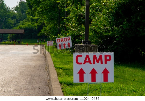 Temporary roadside signs pointing to summer camp
drop off location