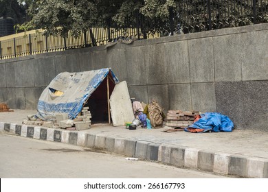 temporary tent of unidentified homeless people on side of street in Delhi, India