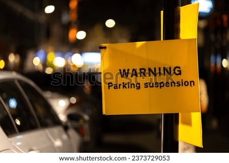 Temporary yellow parking suspension warning sign photo at night