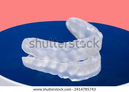 Temporomandibular joint dysfunction.
Dental transparent plastic mouthguard, splint for the treatment of dysfunction of the temporomandibular joints, bruxism, malocclusion, to relax the muscles of the  Stock photo © 